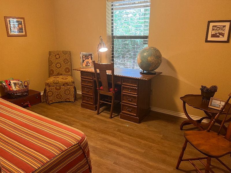 Study with desk overlooking patio and natural area.