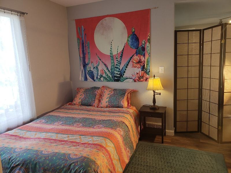 Private full-size bed, desk, and book shelves, separated from living room and kitchen