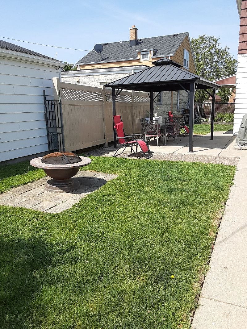 Fenced Yard with Patio Gazebo and Fire Pit and Two Grills
