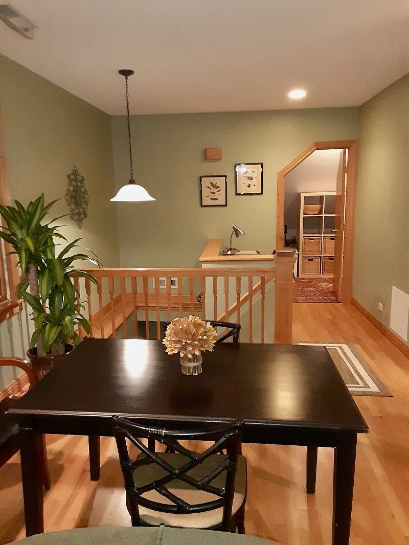 View from couch/tv area looking towards dining table, entry stairs, desk area and changing room