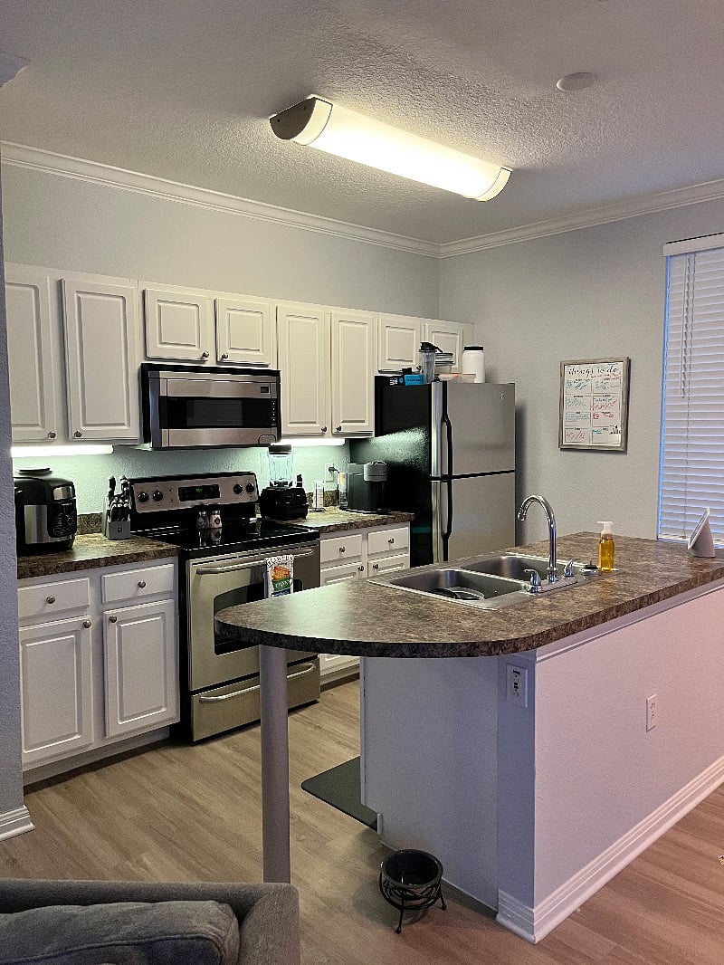 Kitchen equipped with silverware and pots and pans. Also includes a dishwasher, microwave and oven. Features an air fryer. also includes full-size refrigerator.