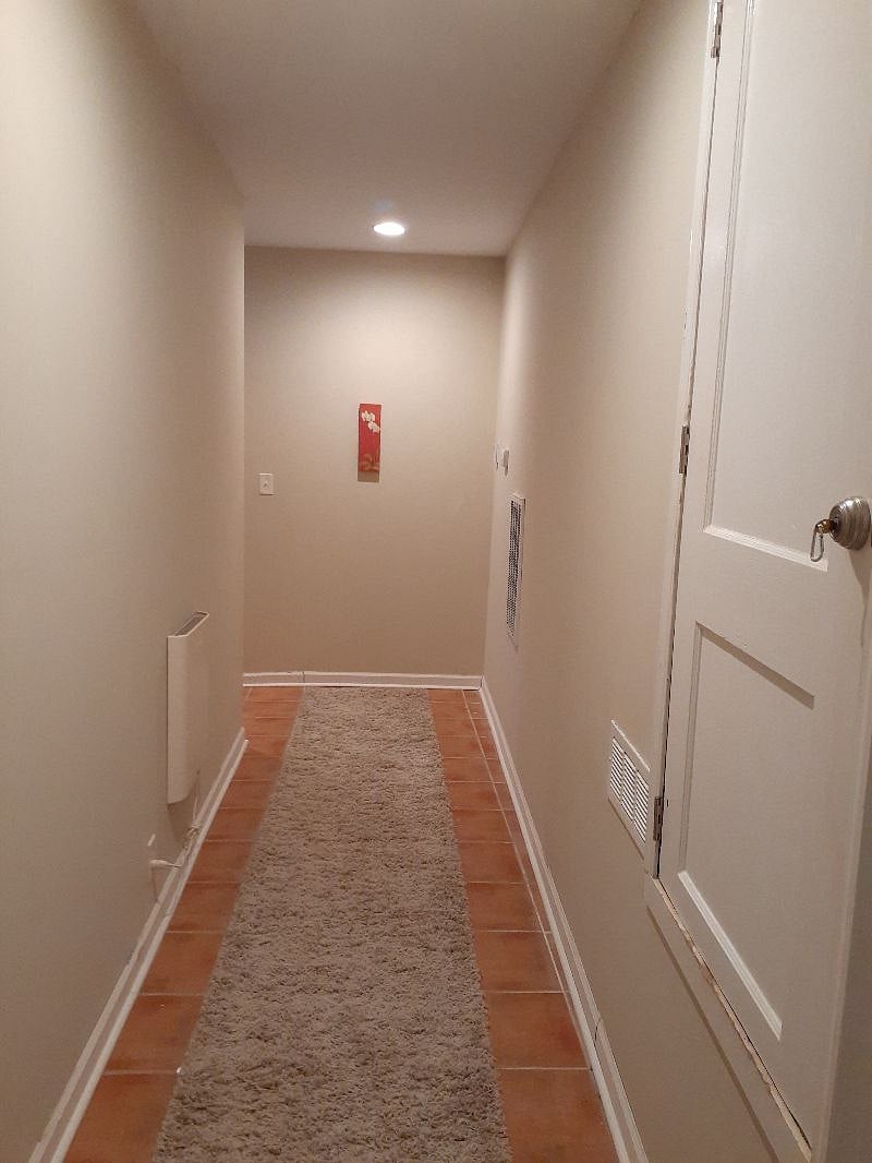 The hallway to the bathroom. Very bright. There is a full length mirror at the end of the hall on the outside of the bathroom door.
