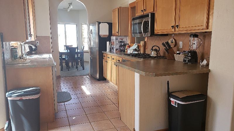 Brightly lit kitchen has garbage disposal, dishwasher, microwave, and plenty of counter space. 