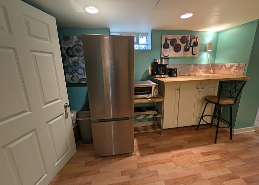 Kitchen Refridgerator and Breakfast bar with storage. That is the Bedroom Door on the Left