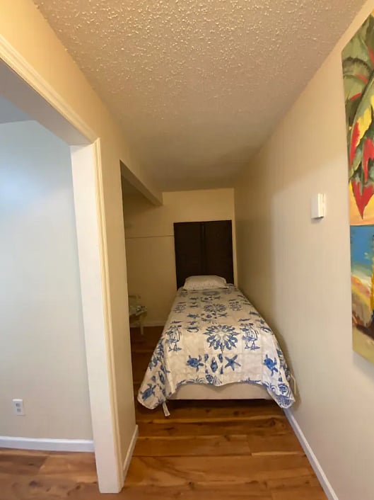 bedroom 2 with added twin bed, portable privacy wall behind bed