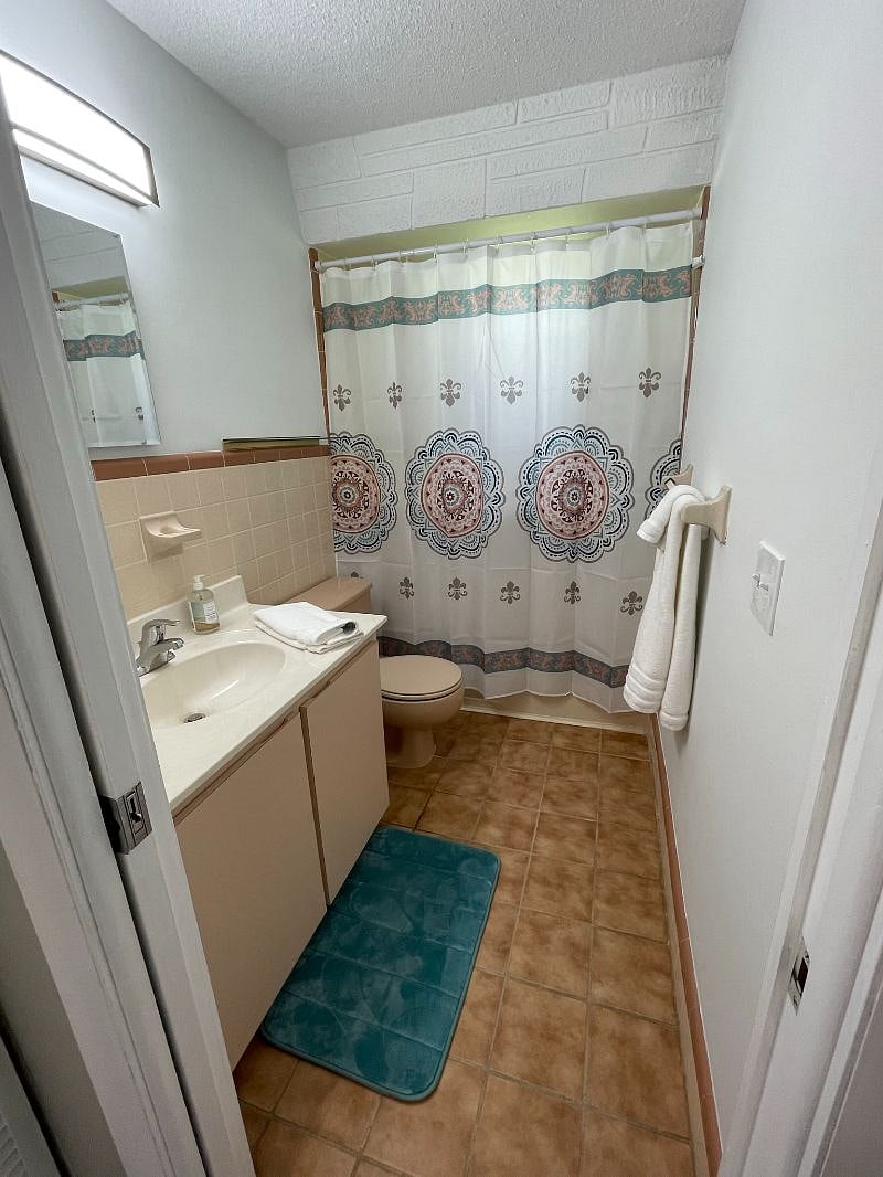 Guest bathroom with walk-in tub/shower that make showering or bathing perfect after a day at the beach and accommodate people with limited mobility.