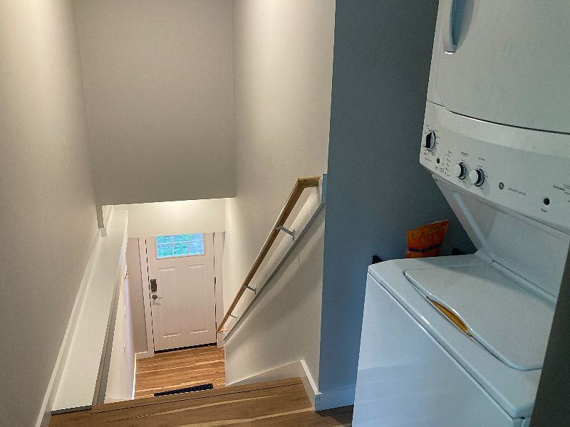 Past the laundry area is the back stairway leading to an exterior door and to the interior door to the garage.