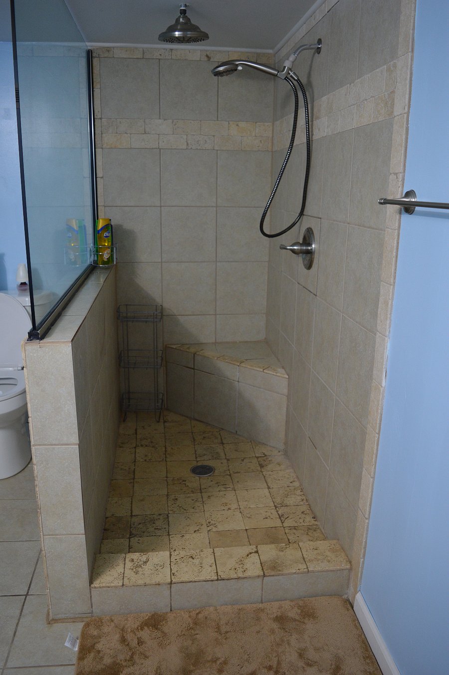 rainforest shower with attachable shower head, sitting area in shower