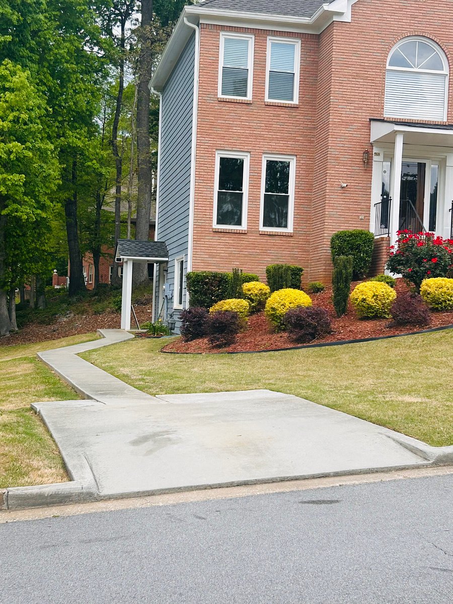 parking pad and sidewalk to entrance basement door. Beautiful landscape yard.