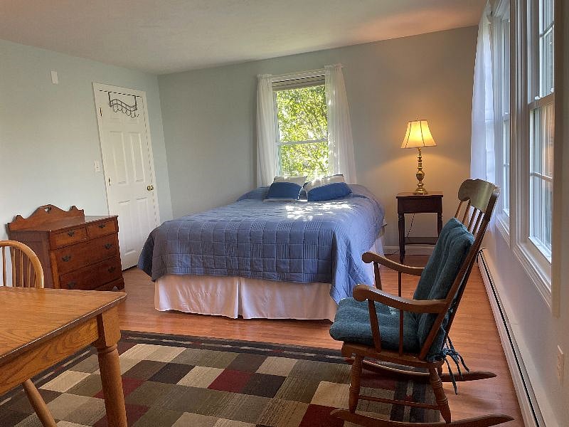 Large bedroom on first floor with queen bed, desk, and adjoining bathroom