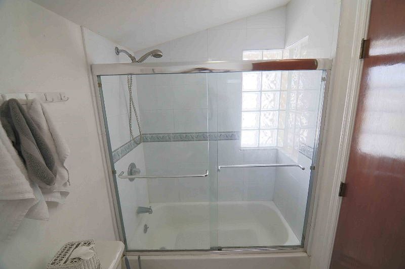 Unique enclosed bathtub shower combo with elegant block glass letting in light. 
