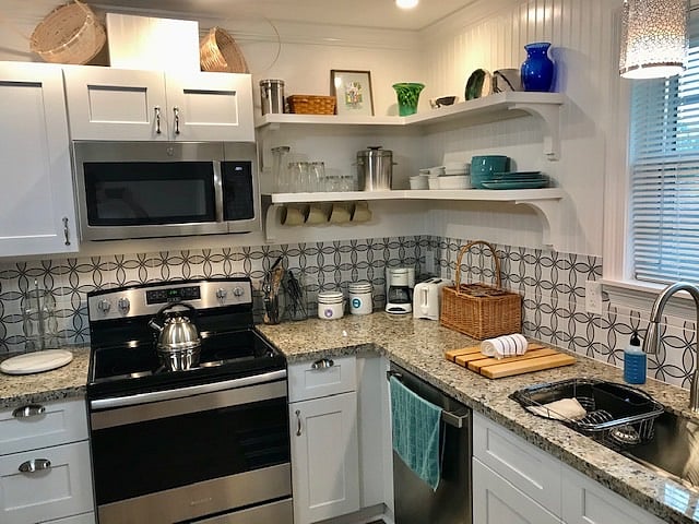 A full operational kitchen with modern stainless appliances and granite countertops 