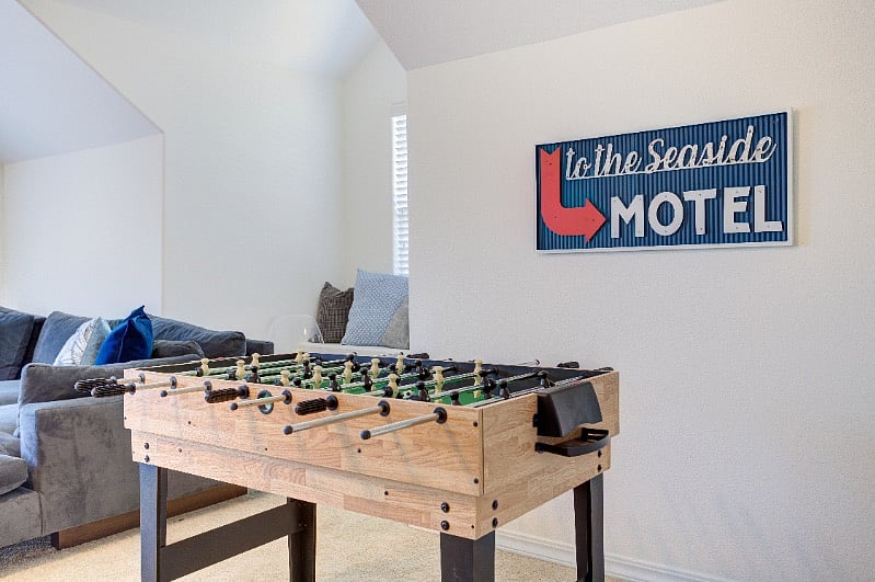 Foosball table upstairs transforms into pool table.