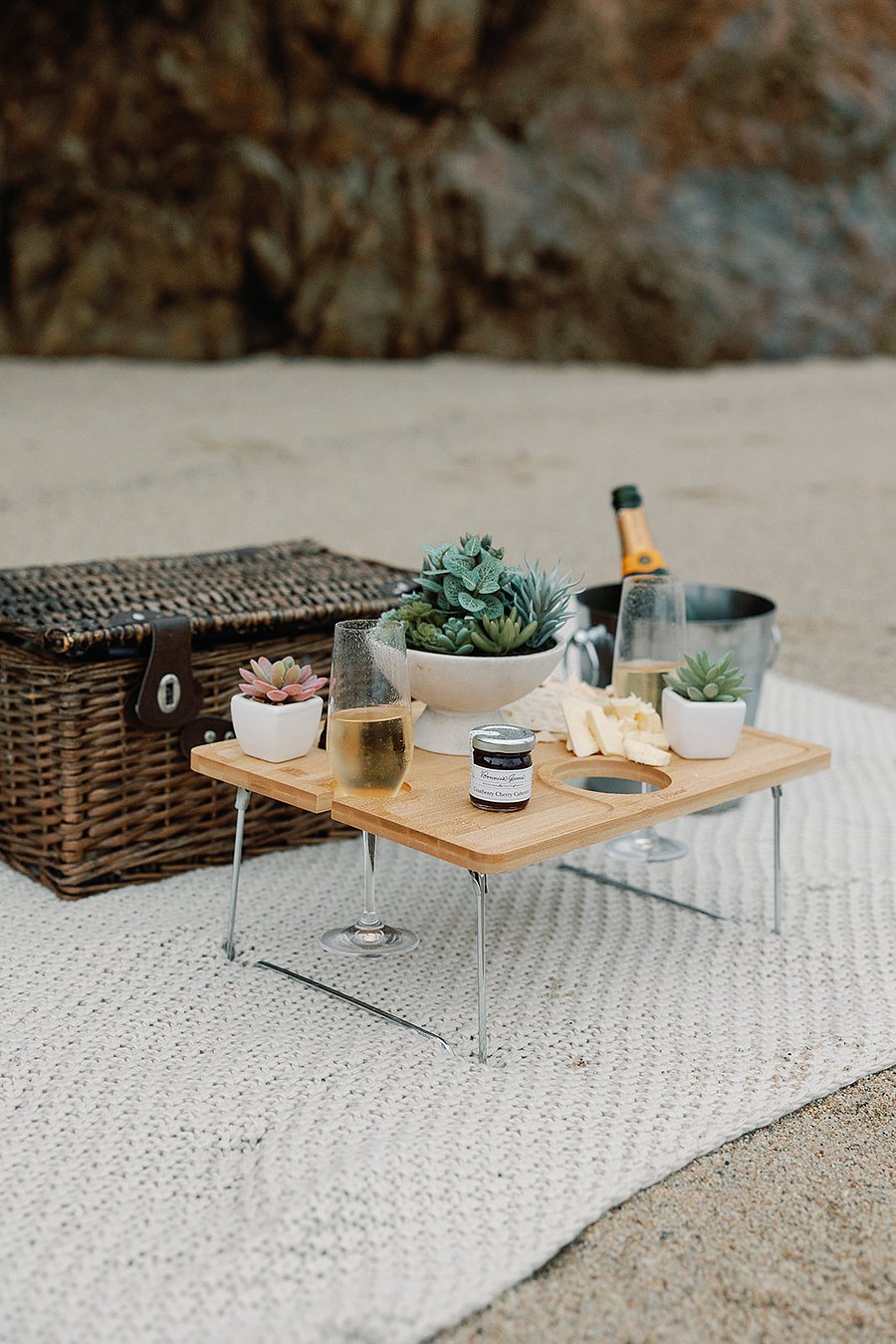 This picnic basket, table, champagne/wine bucket, blanket, glasses, and plants are provided for guests to enjoy. Its the setup we used on our engagement day, and wed love for you to explore and experience the coastline with it as well.