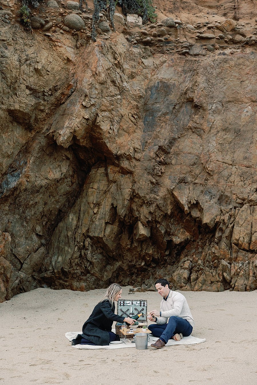 This picnic basket, table, champagne/wine bucket, blanket, glasses, and plants are provided for guests to enjoy. Its the setup we used on our engagement day, and wed love for you to explore and experience the coastline with it as well.