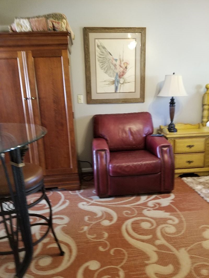 Microwave inside armoire with drawers.