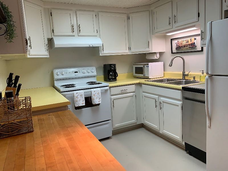 Full kitchen with full size electric range and refrigerator, dishwasher, microwave and coffee maker. 
