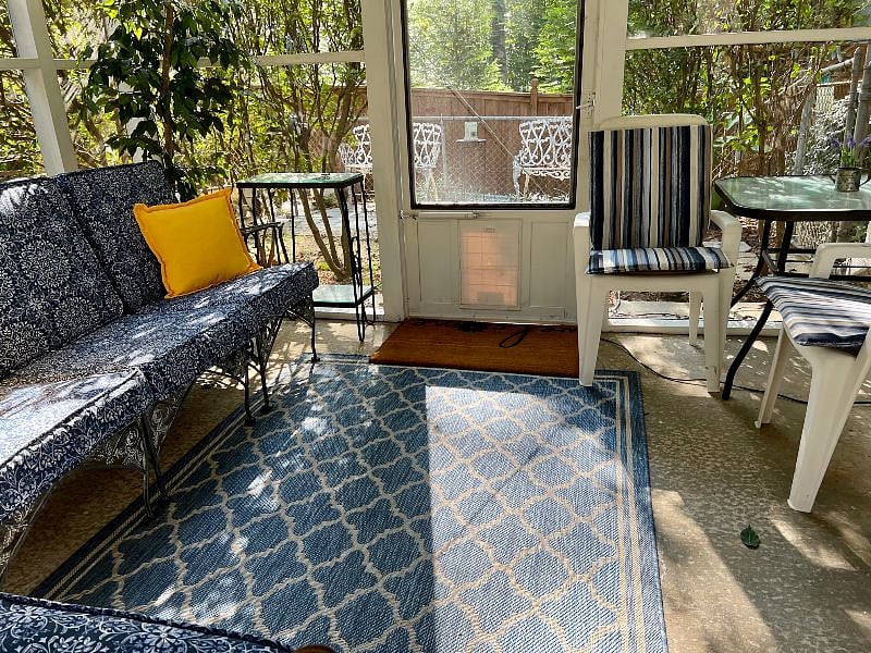 View looking from screened in porch to the outdoor seating patio.
