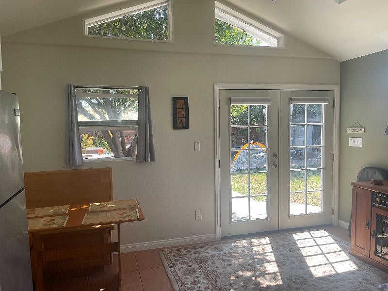 Vaulted ceiling in the spacious living/dining area creates a wide open feeling and the windows and french doors make for peaceful views of the yard.