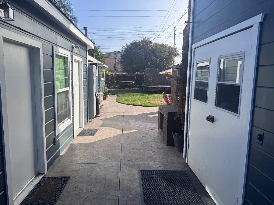 Laundry machines are accessible (behind the two white double doors) in the walkway between the guest house and the front house.