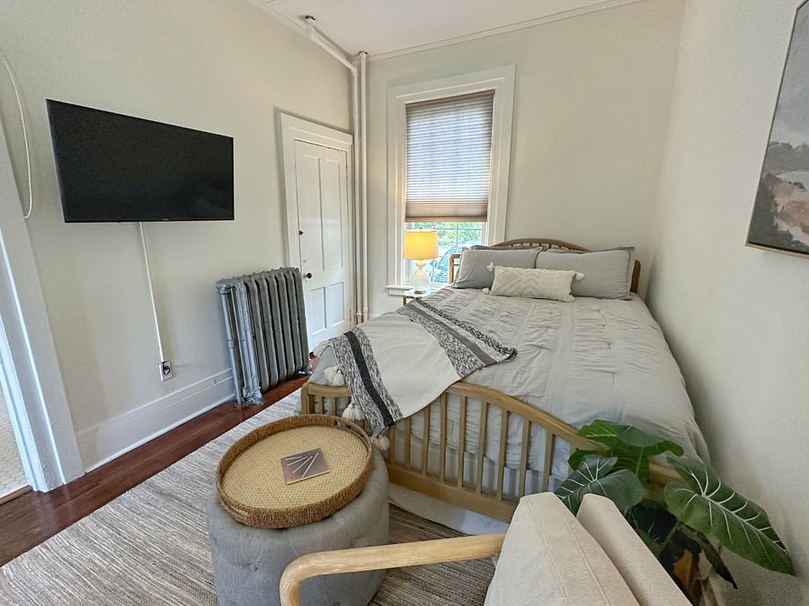 Queen size bed with large closet and smart TV.
