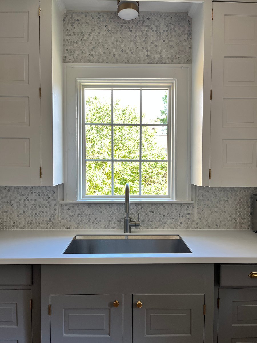 Sweet picture window above wide basin sink with garbage disposal.