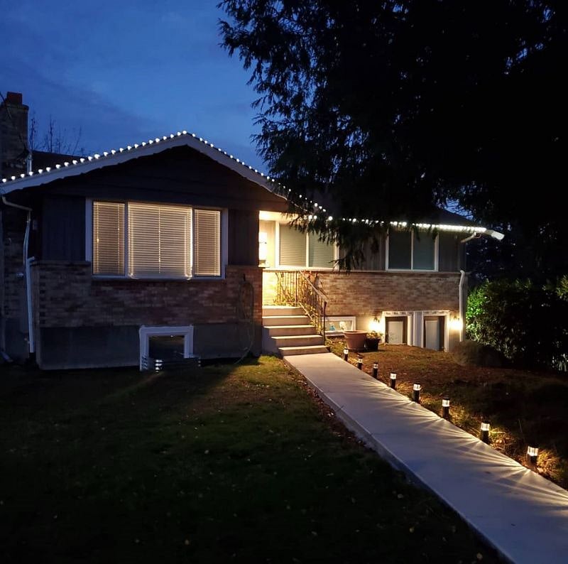 Front exterior at Christmas time with lights. Two doors downstairs include main entrance to the apartment, the other owner's storage.