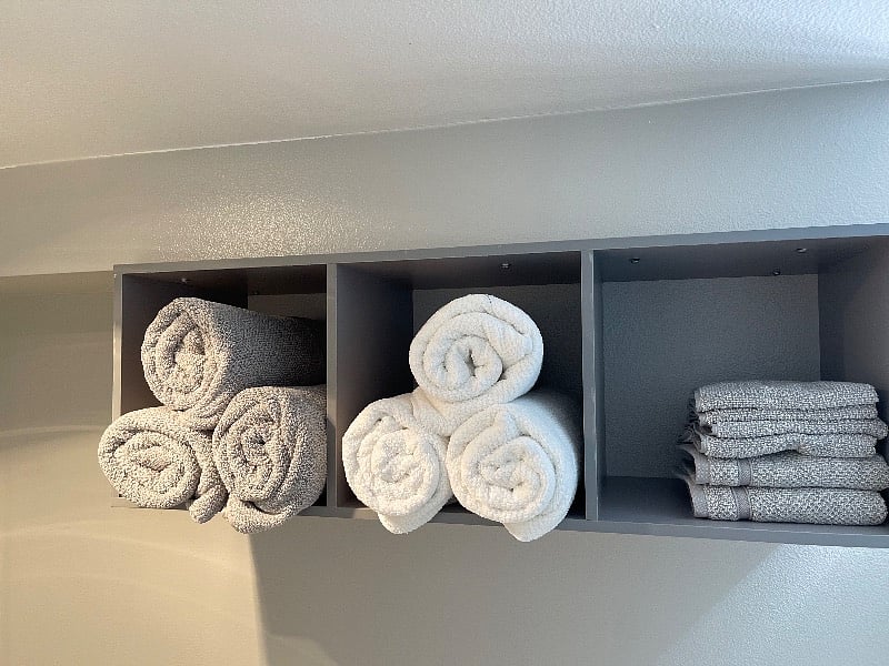 Plush towels stocked in bathroom and extra storage.