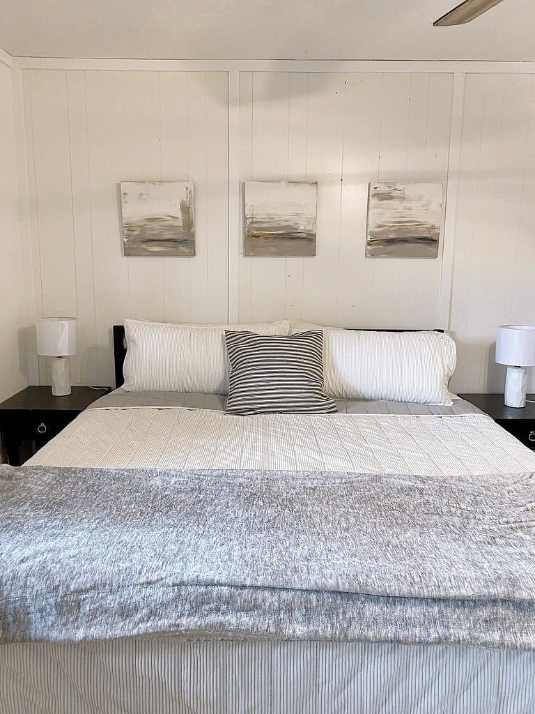Bedroom 1 has a king sized bed and two nightstands with. lamps