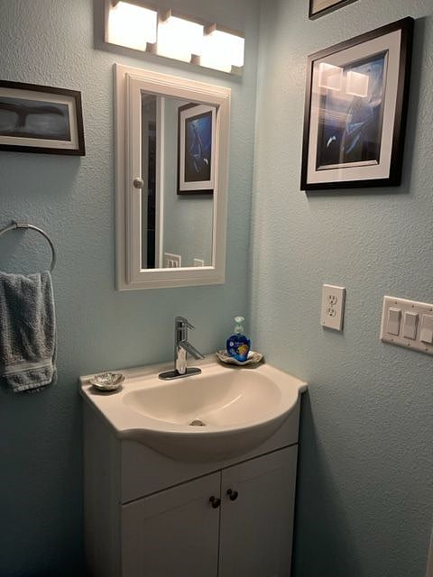 Free standing sink with storage and a medicine cabinet.  