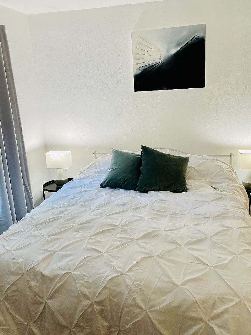 Comfortable queen size bed with darkening window curtains