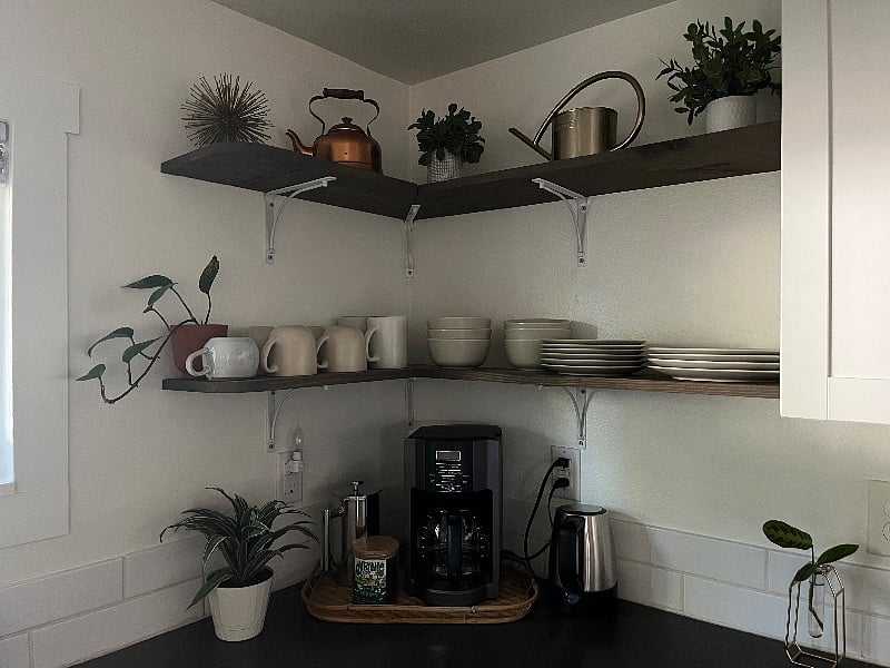 Open shelving in kitchen with ample dishes and mugs. Plastic kids plates also available in cupboards.