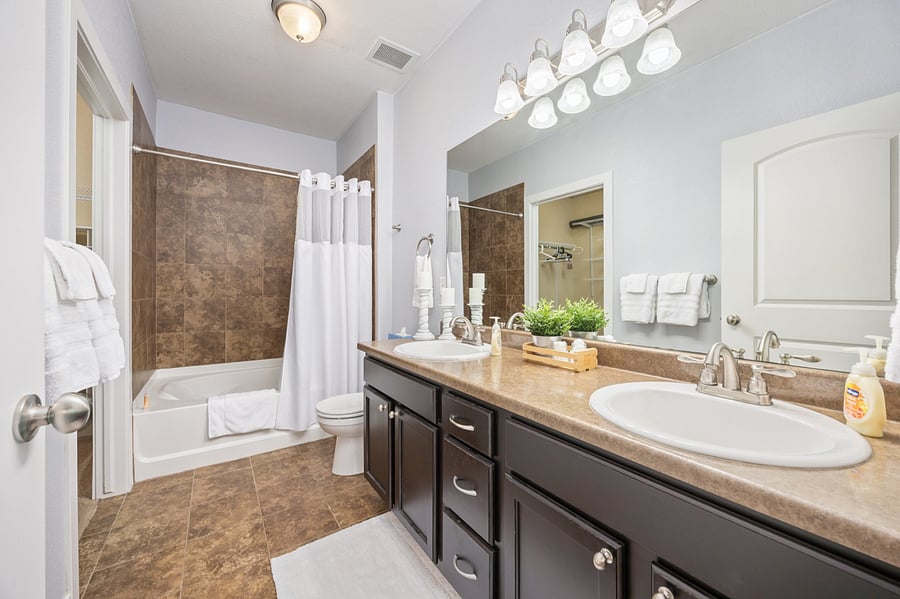 Primary Bathroom with double vanity, and tiled garden tub/shower.