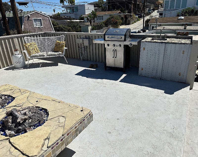 View of loveseat, 5 burner natural gas grill and outdoor sink.