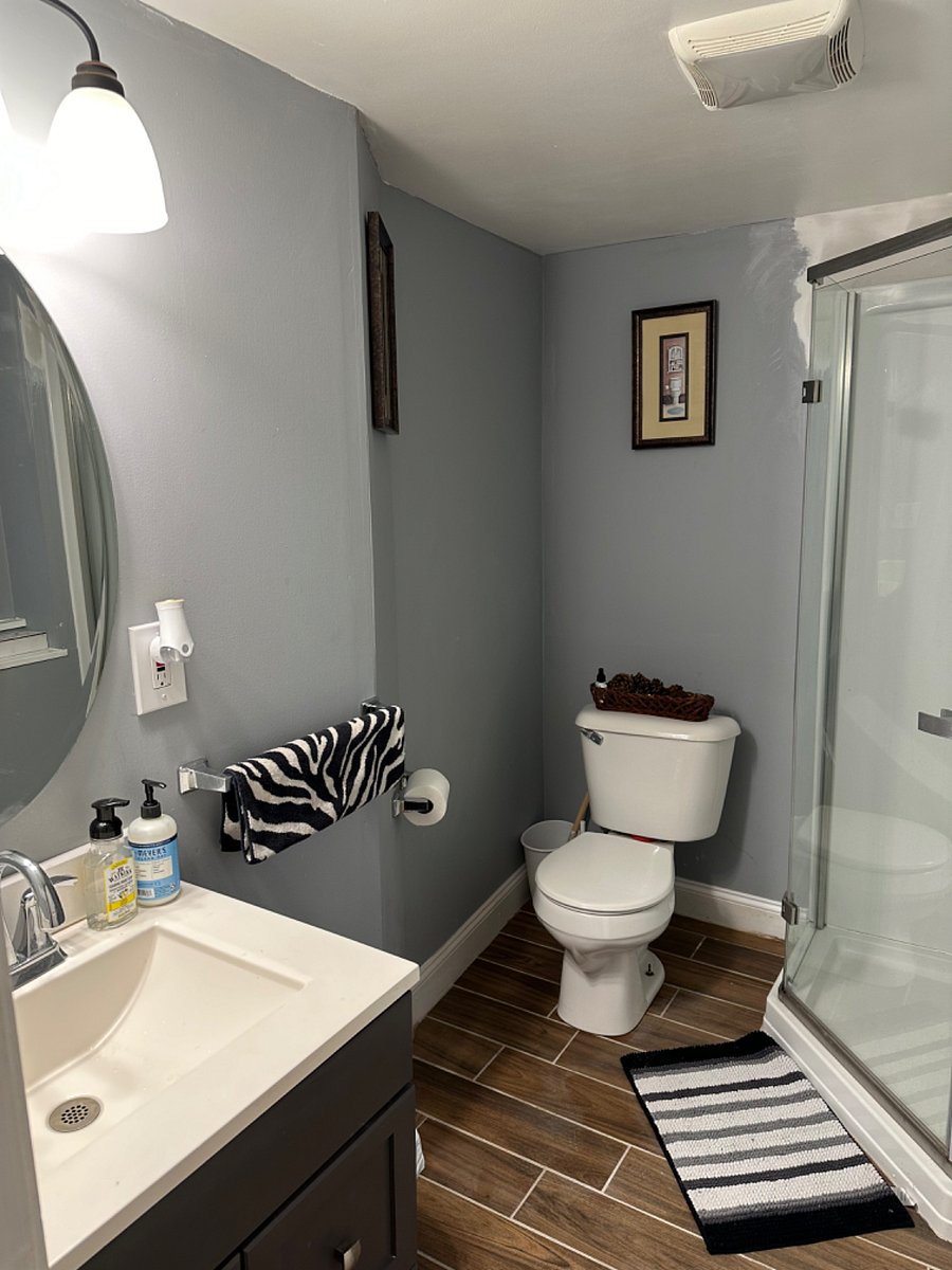 Full size bathroom sink with drawers and bathroom standing shower with shelves, with fan and full size window for good aeration. 