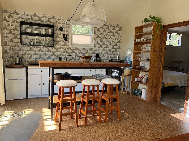 Efficiency kitchen with microwave, toaster oven, mini fridge, electric kettle, convection cooktop, and kitchen essentials. 