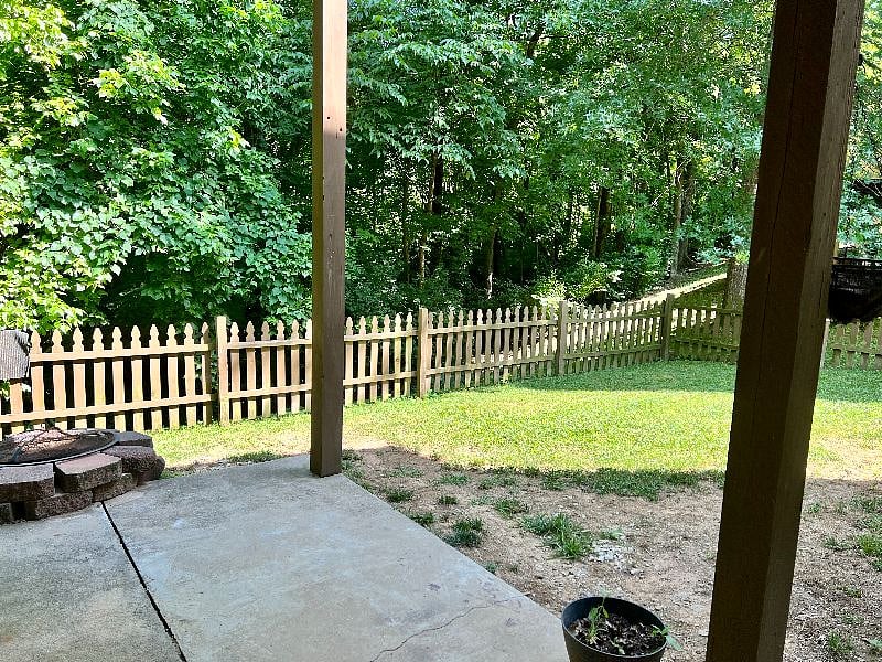 Small fenced in yard, with fire pit, overlooking the woods
