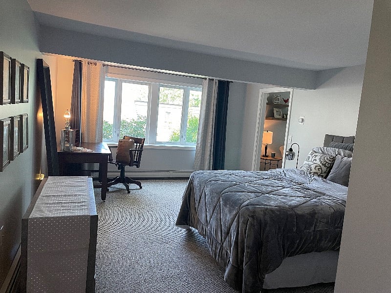 Bedroom with large casement window area. Blackout draperies.