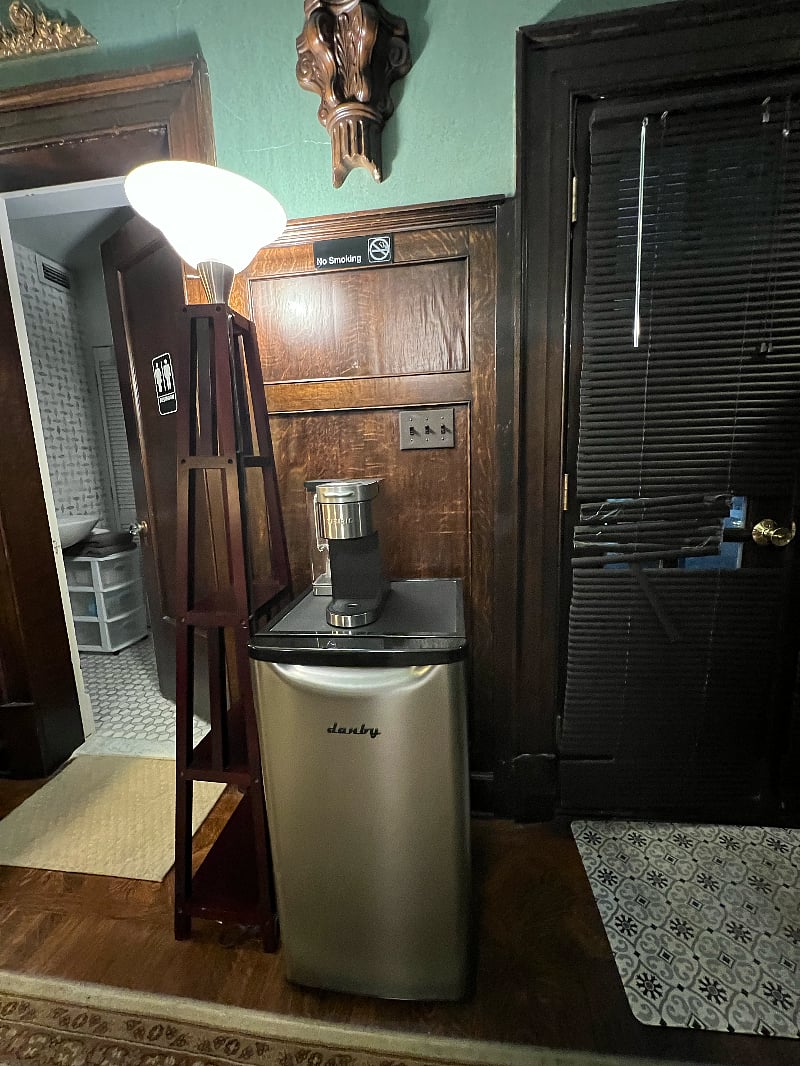 Mini fridge and coffee maker in walnut paneled room