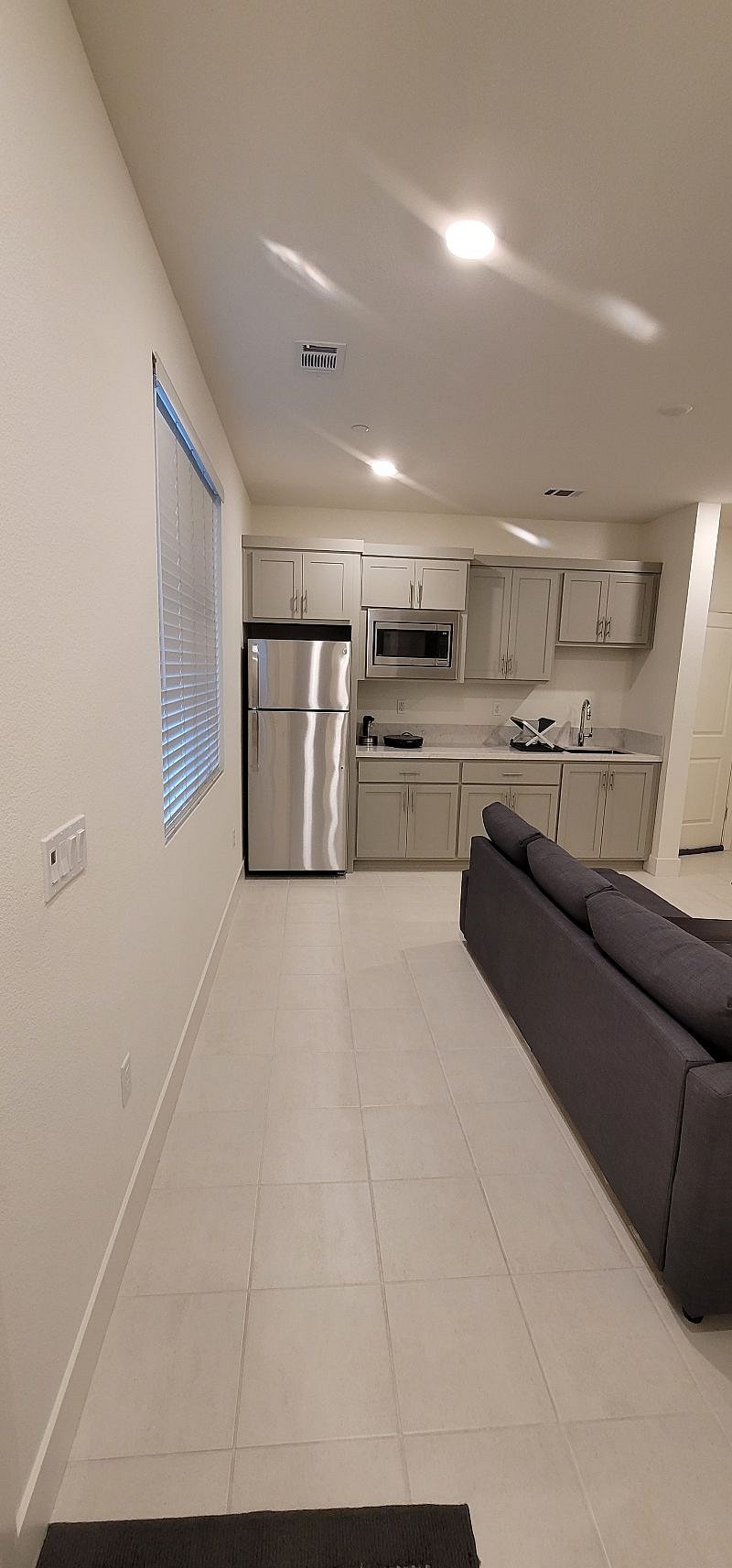 Kitchenette with microwave and electric oven combination, refrigerator with freezer, 8" cooktop, fullsize kitchen sink, and cabinet space.