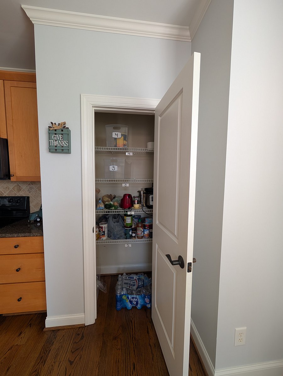 Organized shared pantry with designated shelf space for each room's groceries and essentials.