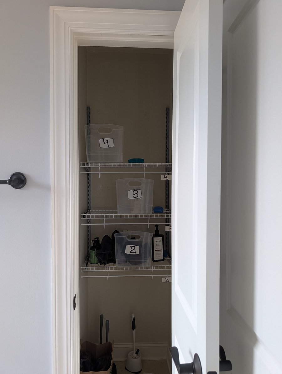 Organized shared bathroom with a designated shelf and personal storage container for each room's shampoo, toiletries, and essentials.