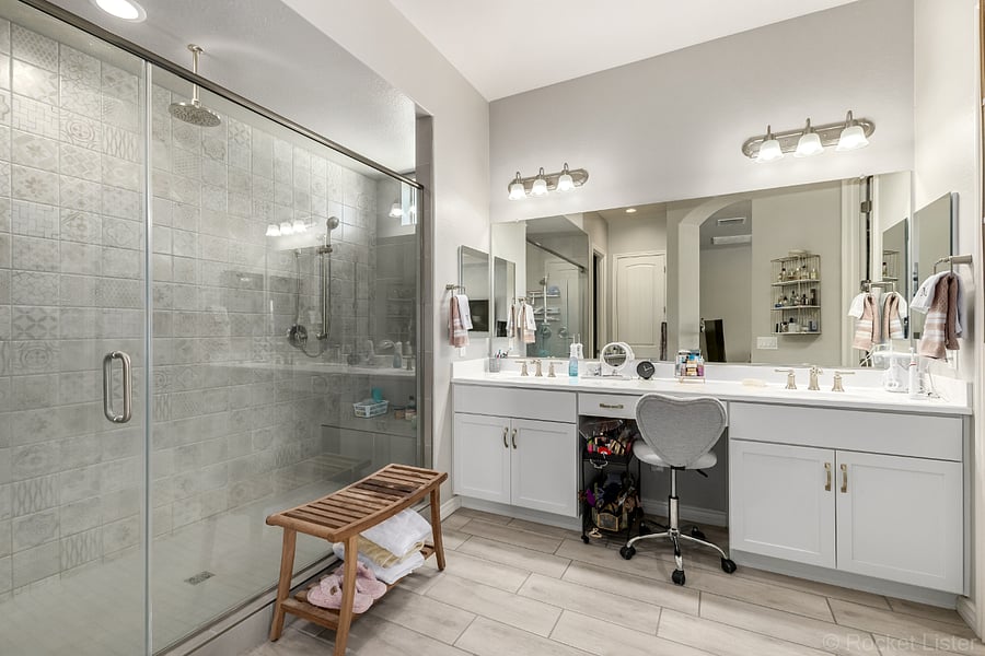 Primary bathroom/double sink. Three shower heads and sitting area.