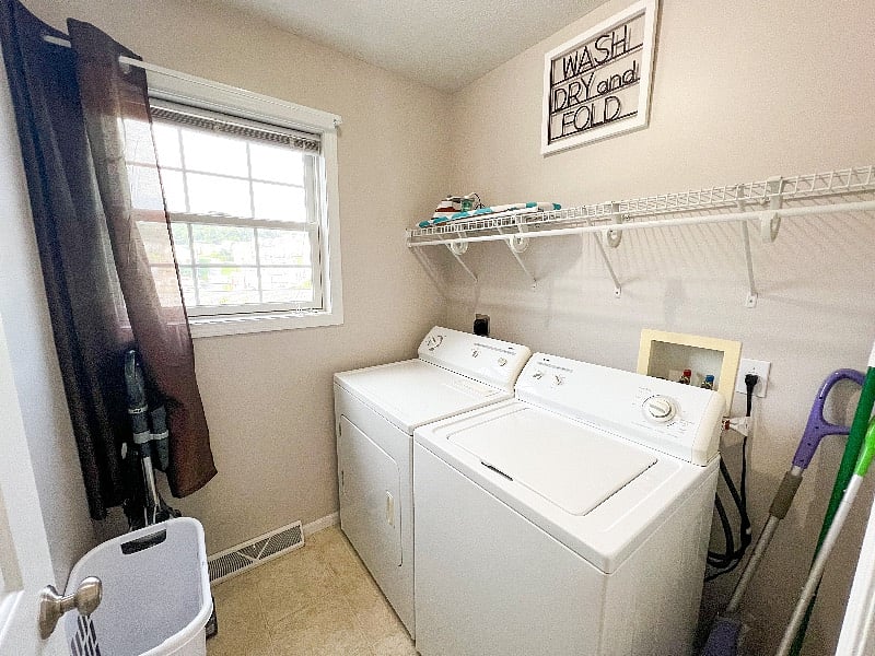 Laundry room with hamper for clean laundry! Vacuum, brooms, & mops found here!