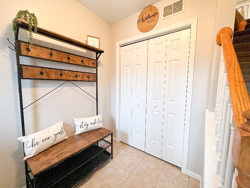 Welcome home! This is the front entrance way. You will find several spaces to hang your coat, hat, or bags, & 2 racks under the bench to leave your shoes!