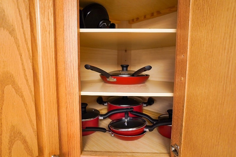 Pots & pans in upper corner cabinet near sink.