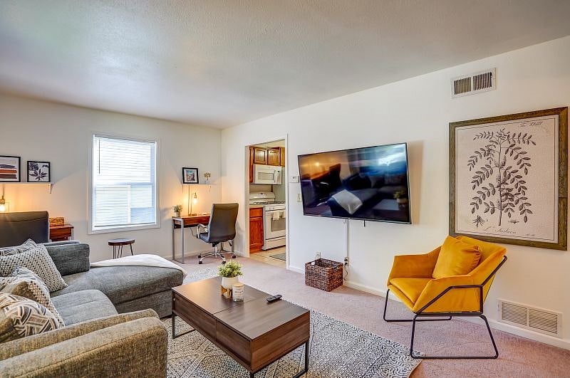 Living room with 65" Roku smart TV, sectional chase sofa, and extra chair.