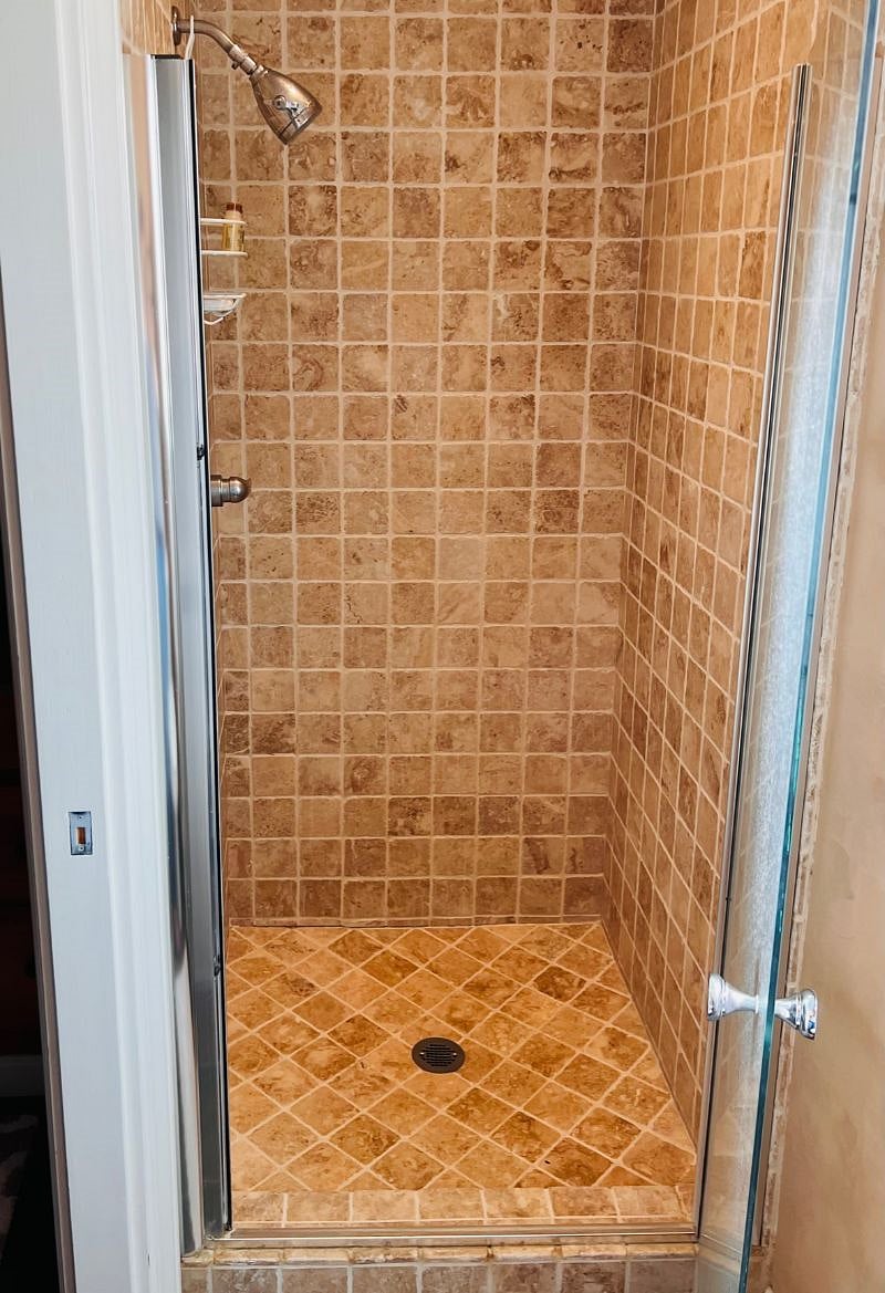 Travertine tile shower with mini toiletries to get you started