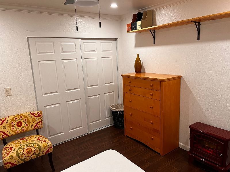 Spacious closet with shelf and shoe rack and a large dresser in the bedroom