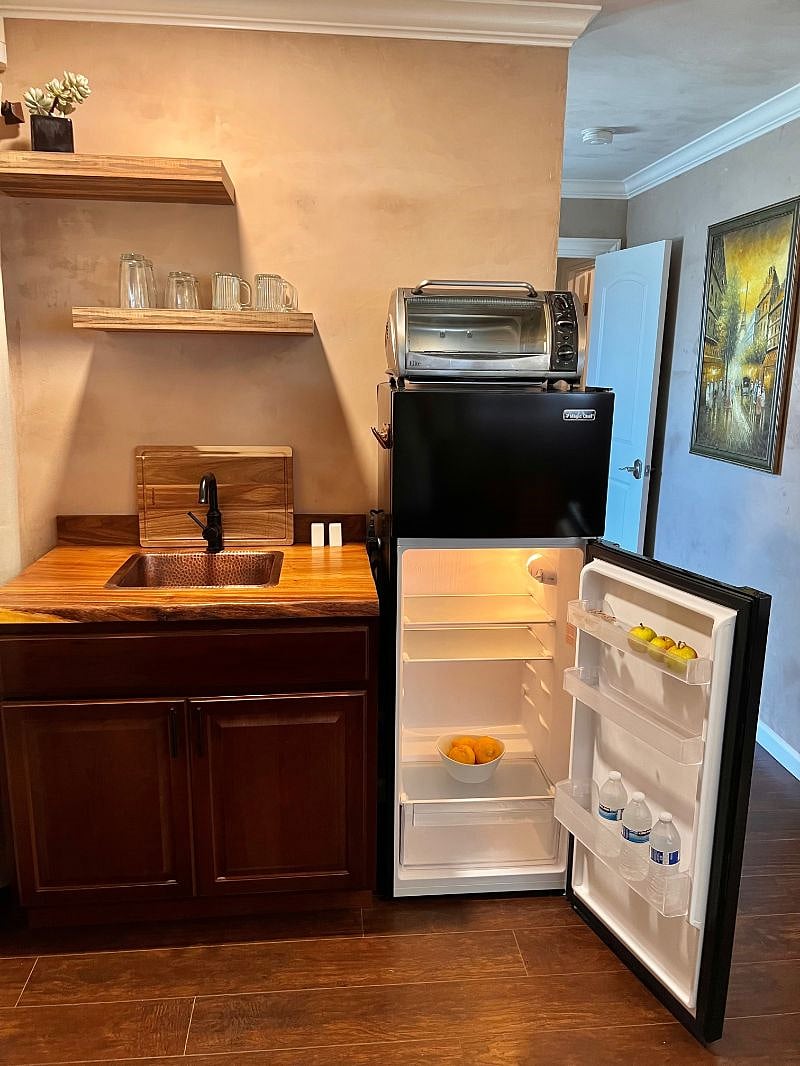 Live edge butcher block counter with copper sink and a refrigerator large enough to hold your weeks groceries (7.1c')